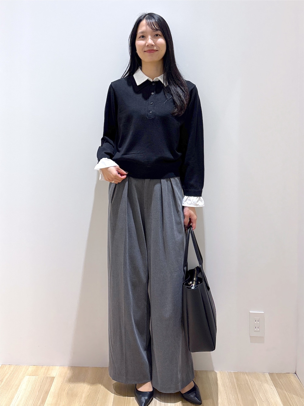 ブラック系のニット/セーター、グレー系のその他パンツ、ブラック系のトートバッグを着用したレディースの秋コーディネートの2枚目の写真
