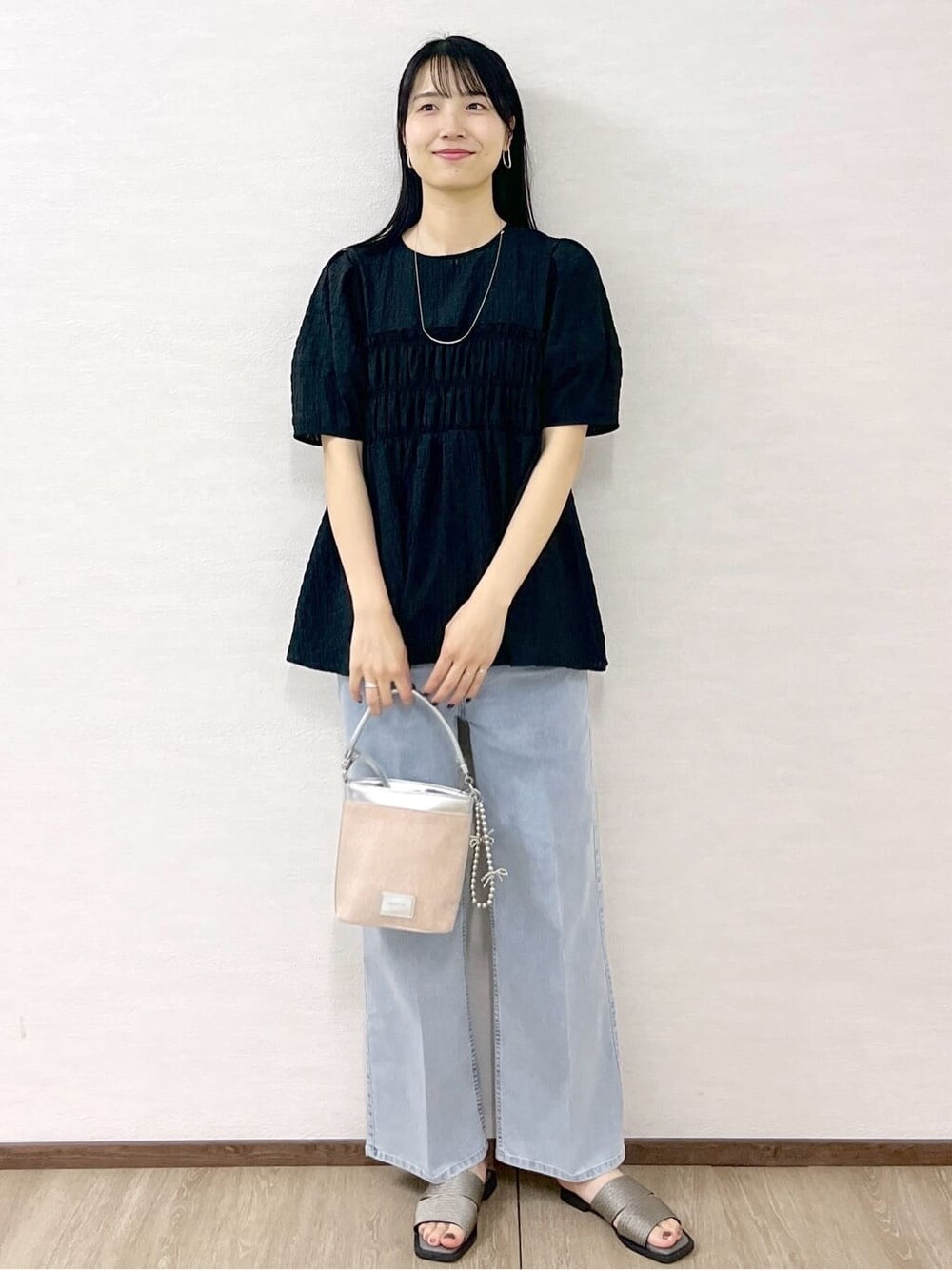 ブラック系のシャツ/ブラウス、ブルー系のデニムパンツ、シルバー系のショルダーバッグを着用したレディースの春コーディネートの10枚目の写真