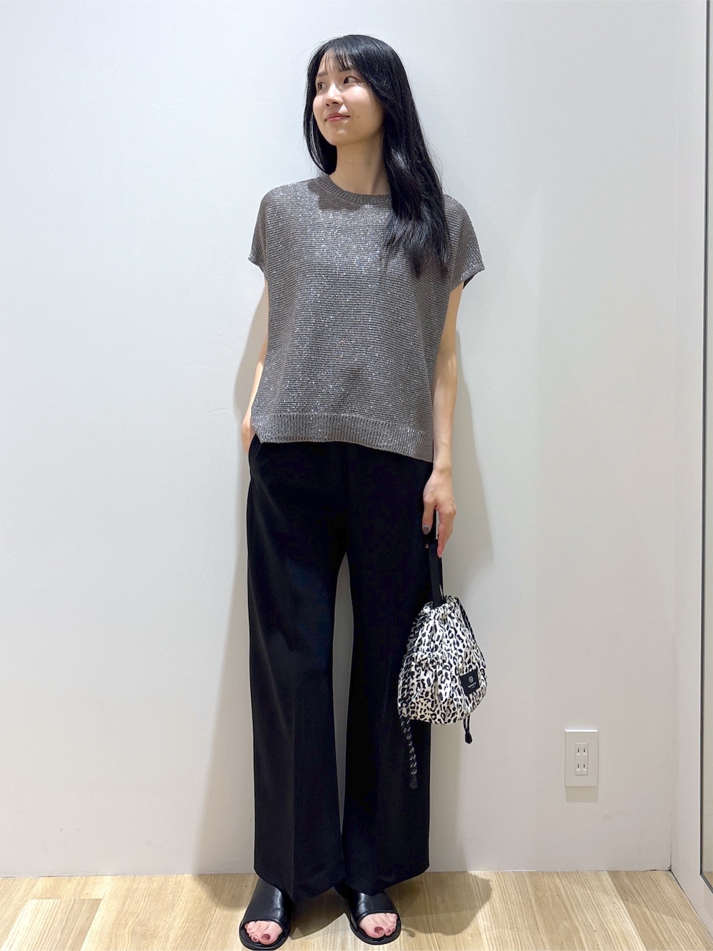 グレー系のニット/セーター、ブラック系のその他パンツ、ベージュ系のショルダーバッグを着用したレディースの夏コーディネートの9枚目の写真