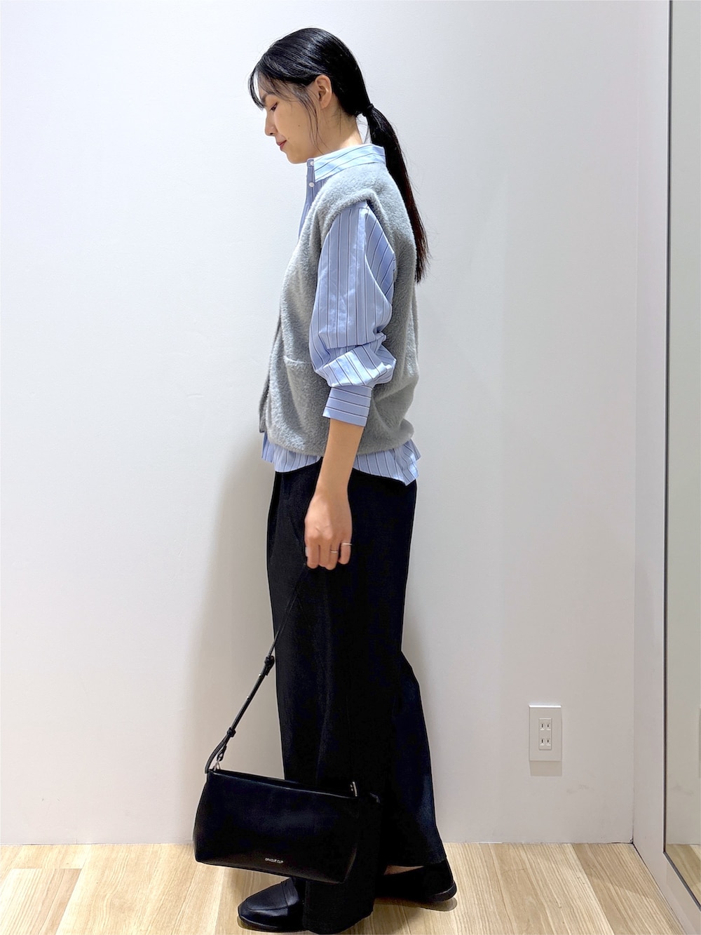 グレー系のニット/セーター、ブラック系のその他パンツ、ブラック系のショルダーバッグを着用したレディースの秋コーディネートの3枚目の写真