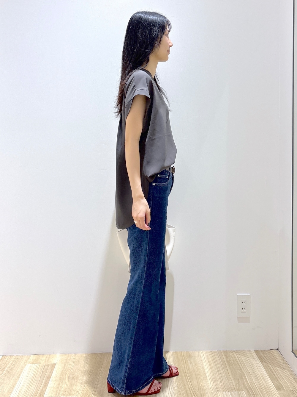 ブルー系のデニムパンツ、ホワイト系のショルダーバッグ、レッド系のサンダルを着用したレディースの夏コーディネートの5枚目の写真