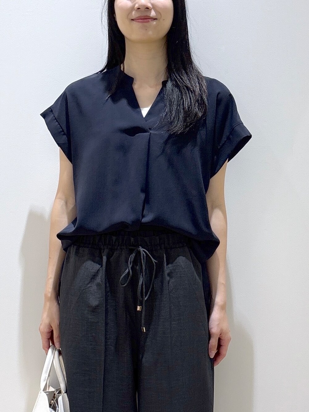 ブラック系のシャツ/ブラウス、グレー系のその他パンツ、ホワイト系のショルダーバッグを着用したレディースの夏コーディネートの6枚目の写真