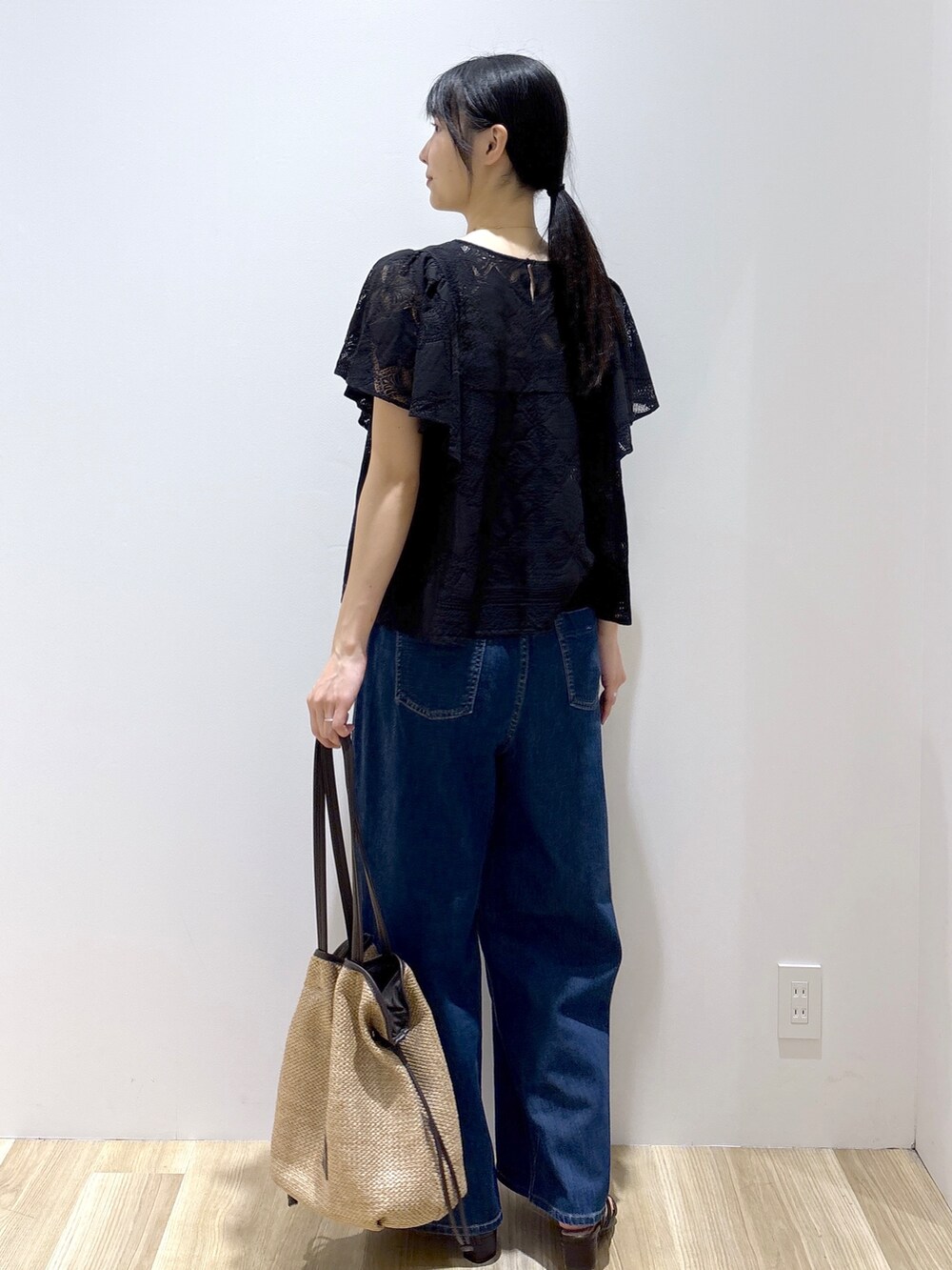 ブラック系のシャツ/ブラウス、ブルー系のデニムパンツ、ベージュ系のトートバッグを着用したレディースの春コーディネートの4枚目の写真
