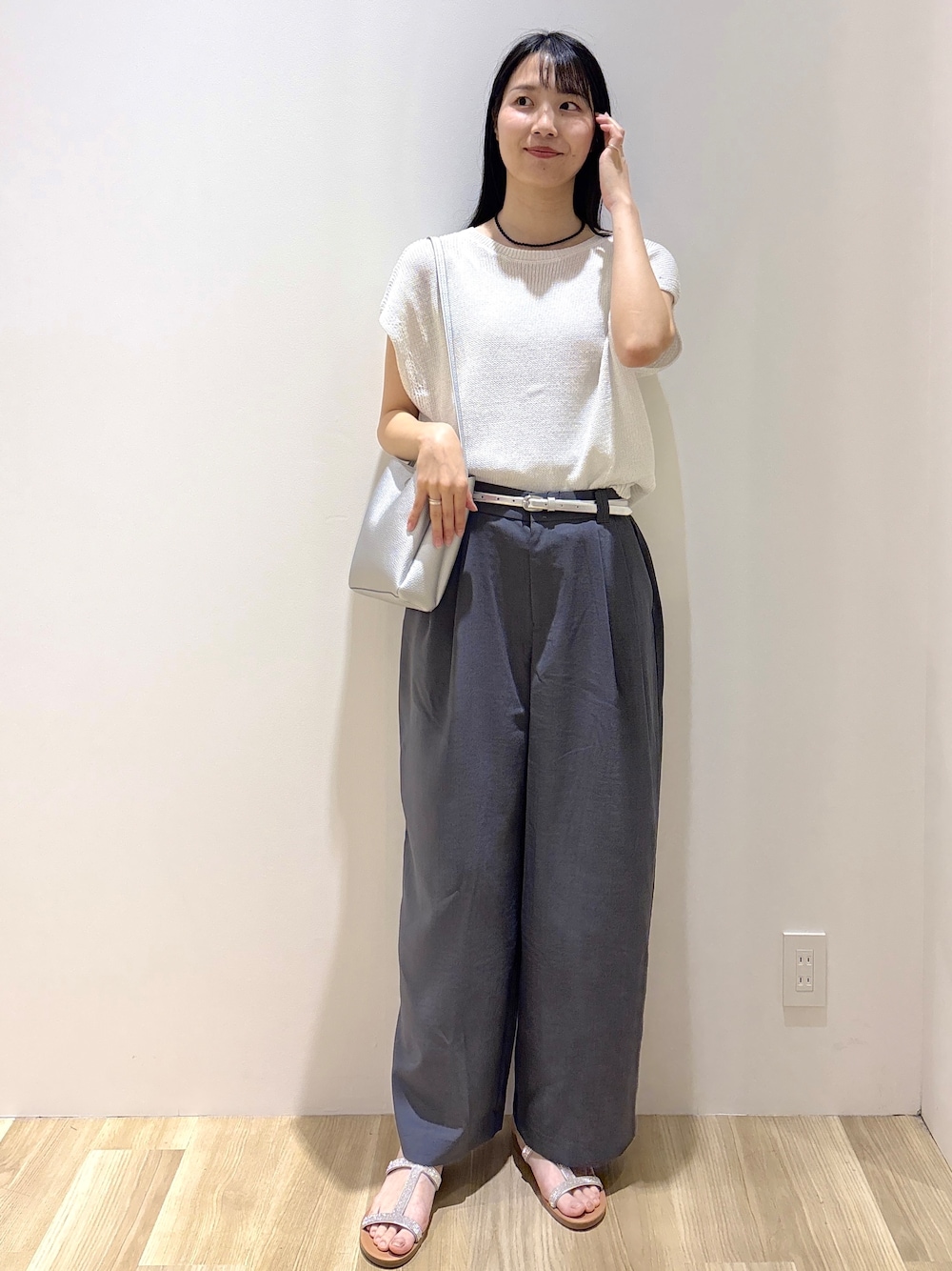 ホワイト系のニット/セーター、グレー系のその他パンツ、シルバー系のショルダーバッグを着用したレディースの夏コーディネートの9枚目の写真