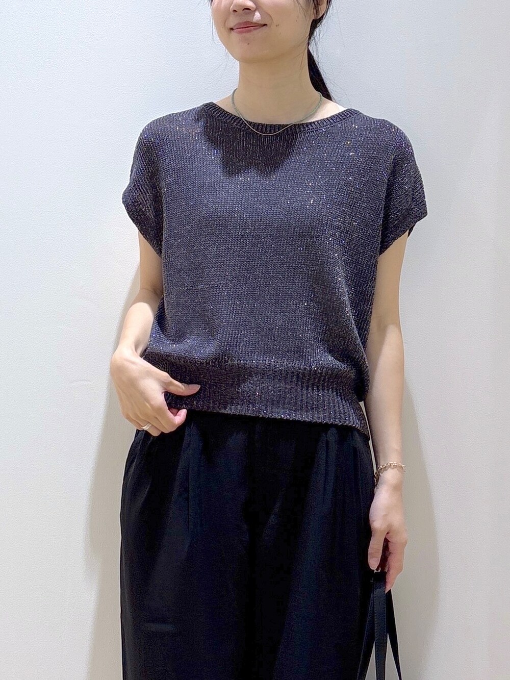 グレー系のニット/セーター、ブラック系のその他パンツ、ブラック系のトートバッグを着用したレディースの夏コーディネートの6枚目の写真