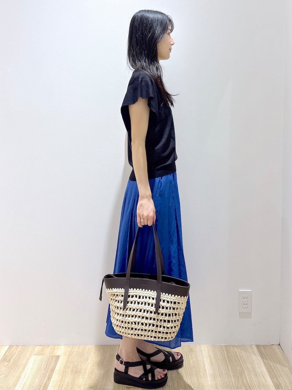 ブラック系のニット/セーター、ブルー系のその他パンツ、ブラウン系のトートバッグを着用したレディースの夏コーディネートの5枚目の写真
