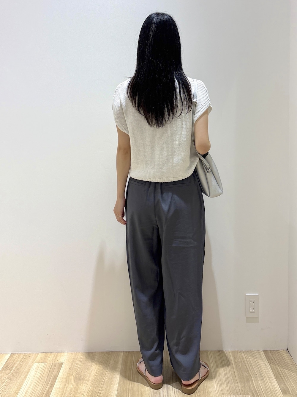 ホワイト系のニット/セーター、グレー系のその他パンツ、シルバー系のショルダーバッグを着用したレディースの夏コーディネートの4枚目の写真