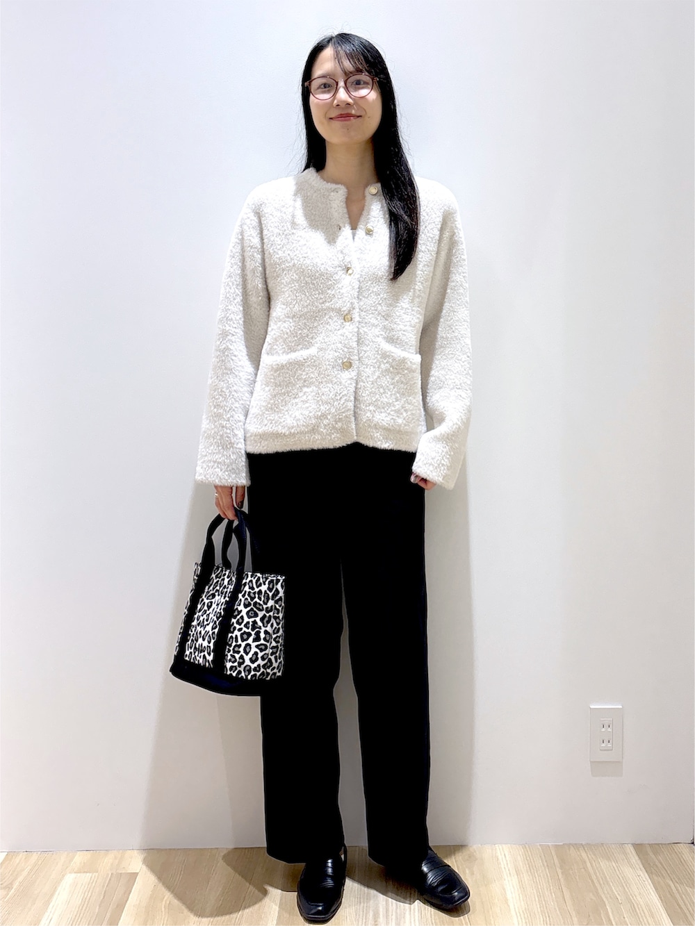 ベージュ系のカーディガン/ボレロ、ブラック系のその他パンツ、ブラック系のトートバッグを着用したレディースの秋コーディネートの2枚目の写真