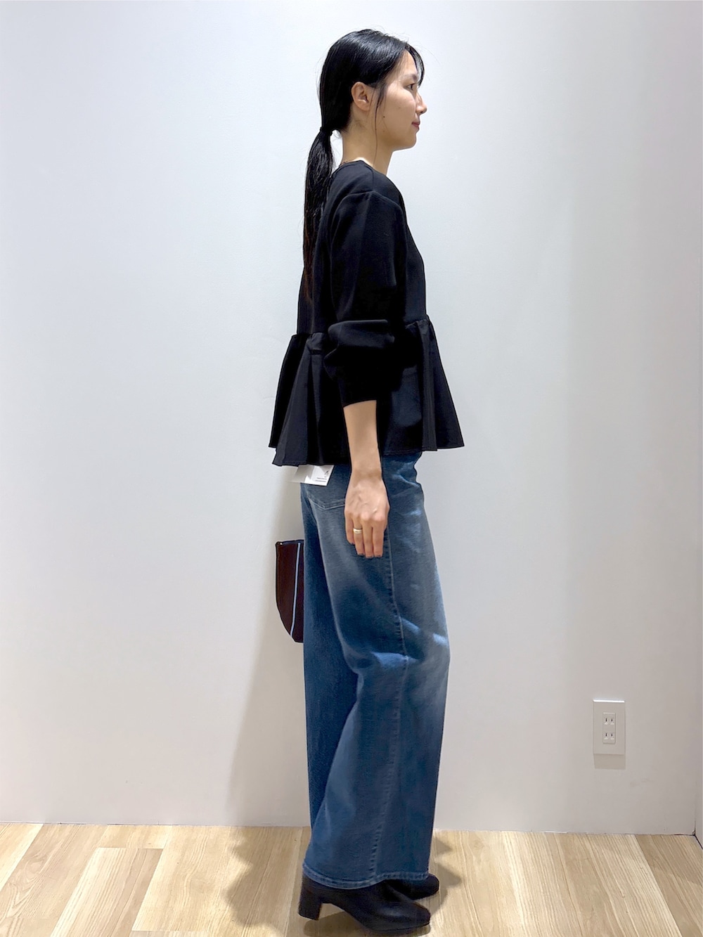ブラック系のTシャツ/カットソー、ブルー系のデニムパンツ、ブラウン系のトートバッグを着用したレディースの秋コーディネートの5枚目の写真