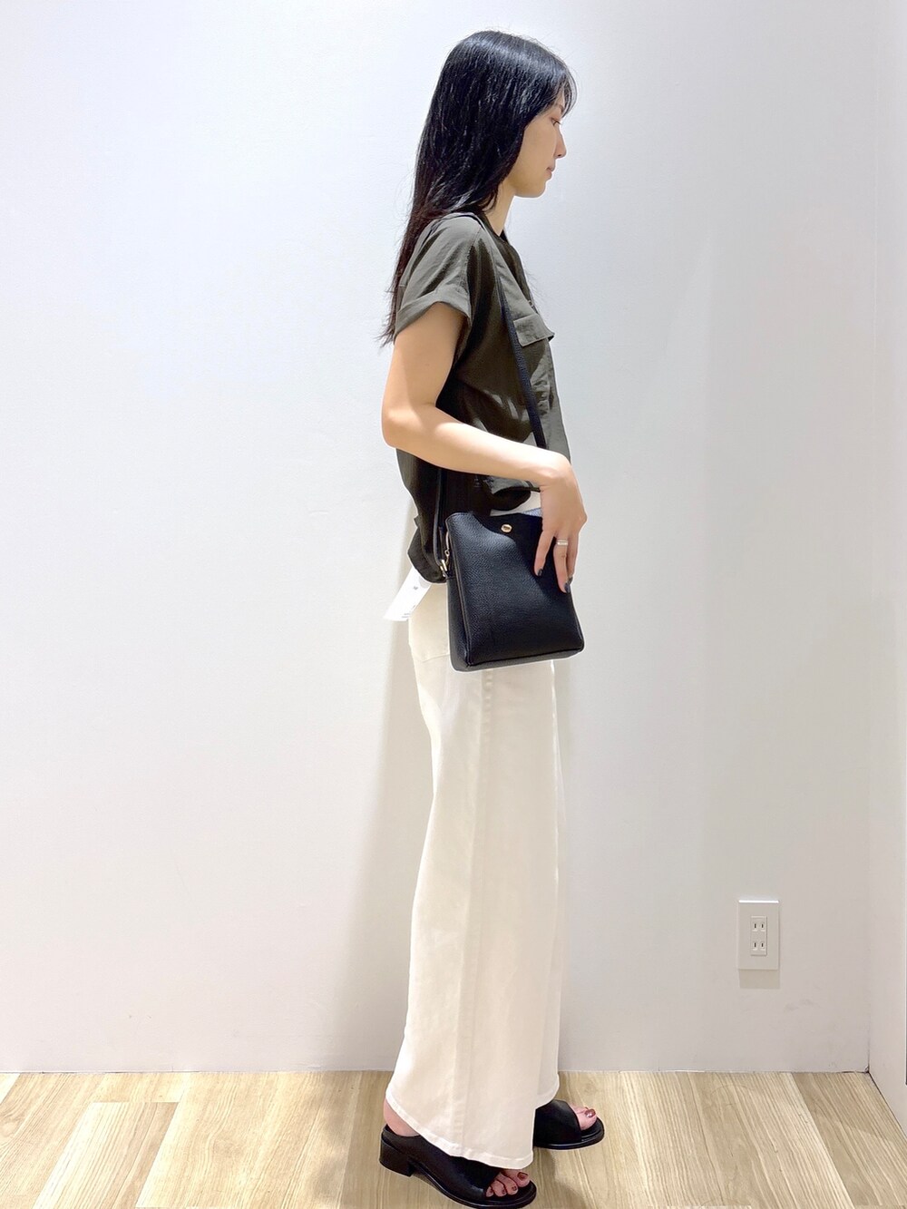 グリーン系のシャツ/ブラウス、ホワイト系のデニムパンツ、ブラック系のショルダーバッグを着用したレディースの夏コーディネートの4枚目の写真