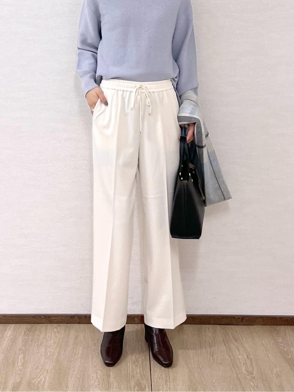 グレー系のノーカラーコート、ブルー系のニット/セーター、ホワイト系のその他パンツを着用したレディースの秋コーディネートの9枚目の写真