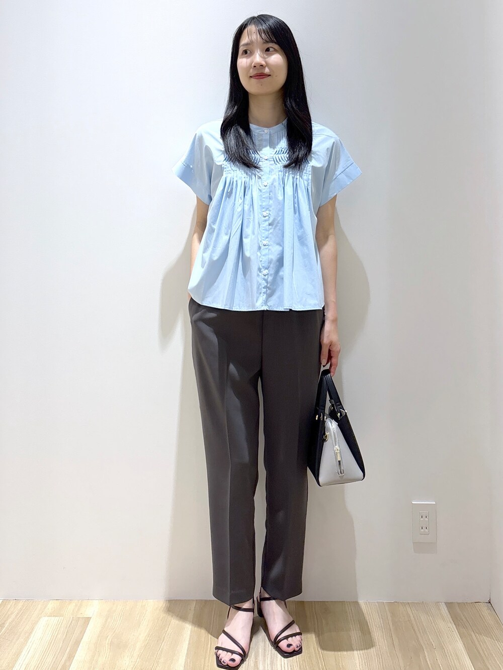 ブルー系のシャツ/ブラウス、グレー系のその他パンツ、ブラック系のショルダーバッグを着用したレディースの夏コーディネートの2枚目の写真