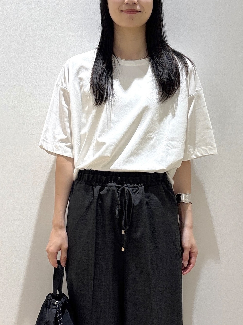 ホワイト系のTシャツ/カットソー、グレー系のその他パンツ、ブラック系のショルダーバッグを着用したレディースの夏コーディネートの5枚目の写真