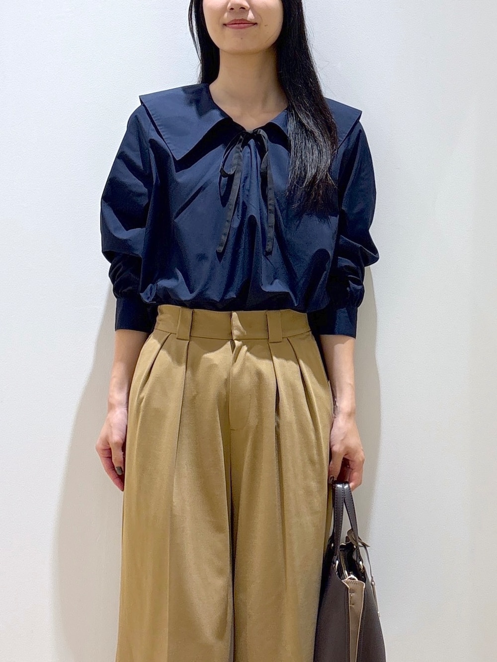 ブルー系のシャツ/ブラウス、イエロー系のその他パンツ、ブラウン系のトートバッグを着用したレディースの秋コーディネートの6枚目の写真