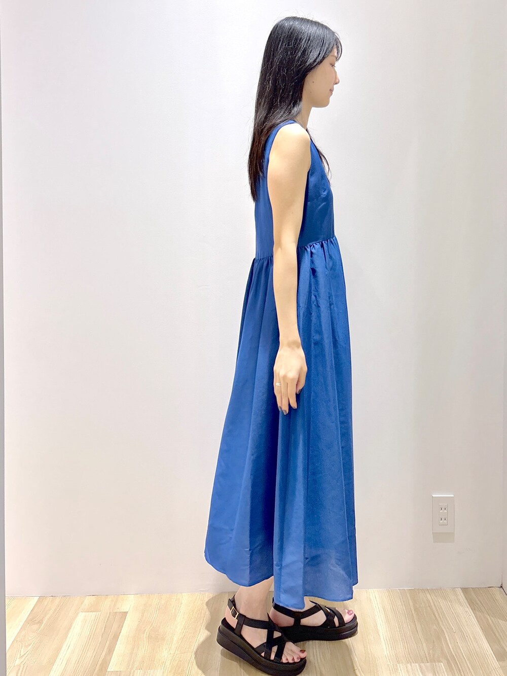 ブルー系のワンピース、ホワイト系のトートバッグ、ブラック系のサンダルを着用したレディースの夏コーディネートの5枚目の写真
