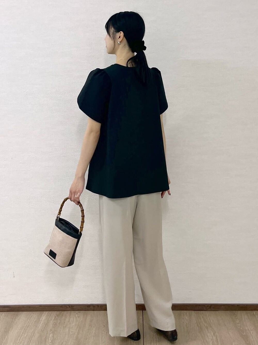 ブラック系のTシャツ/カットソー、ベージュ系のその他パンツ、ブラック系のショルダーバッグを着用したレディースの春コーディネートの5枚目の写真