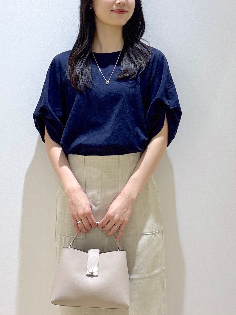 ブルー系のシャツ/ブラウス、ベージュ系のスカート、ベージュ系のハンドバッグを着用したレディースの夏コーディネートの6枚目の写真