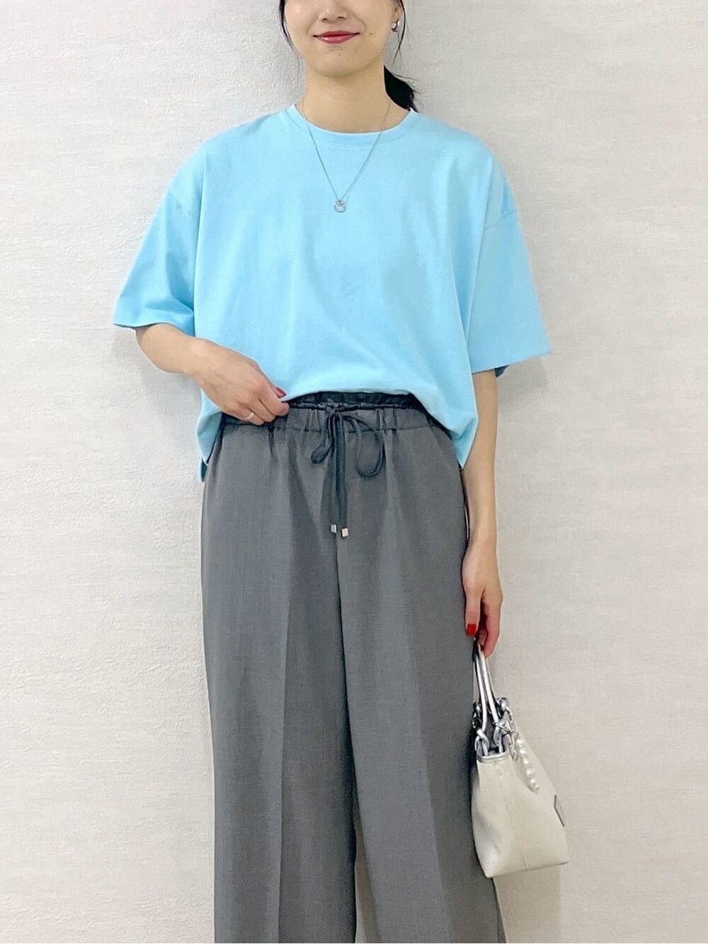 ブルー系のTシャツ/カットソー、グレー系のその他パンツ、シルバー系のトートバッグを着用したレディースの夏コーディネートの7枚目の写真