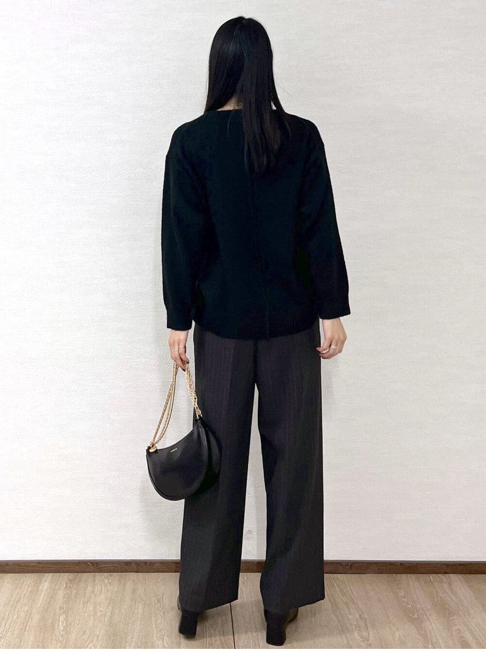 ブラック系のニット/セーター、グレー系のその他パンツ、ブラック系のハンドバッグを着用したレディースの冬コーディネートの4枚目の写真
