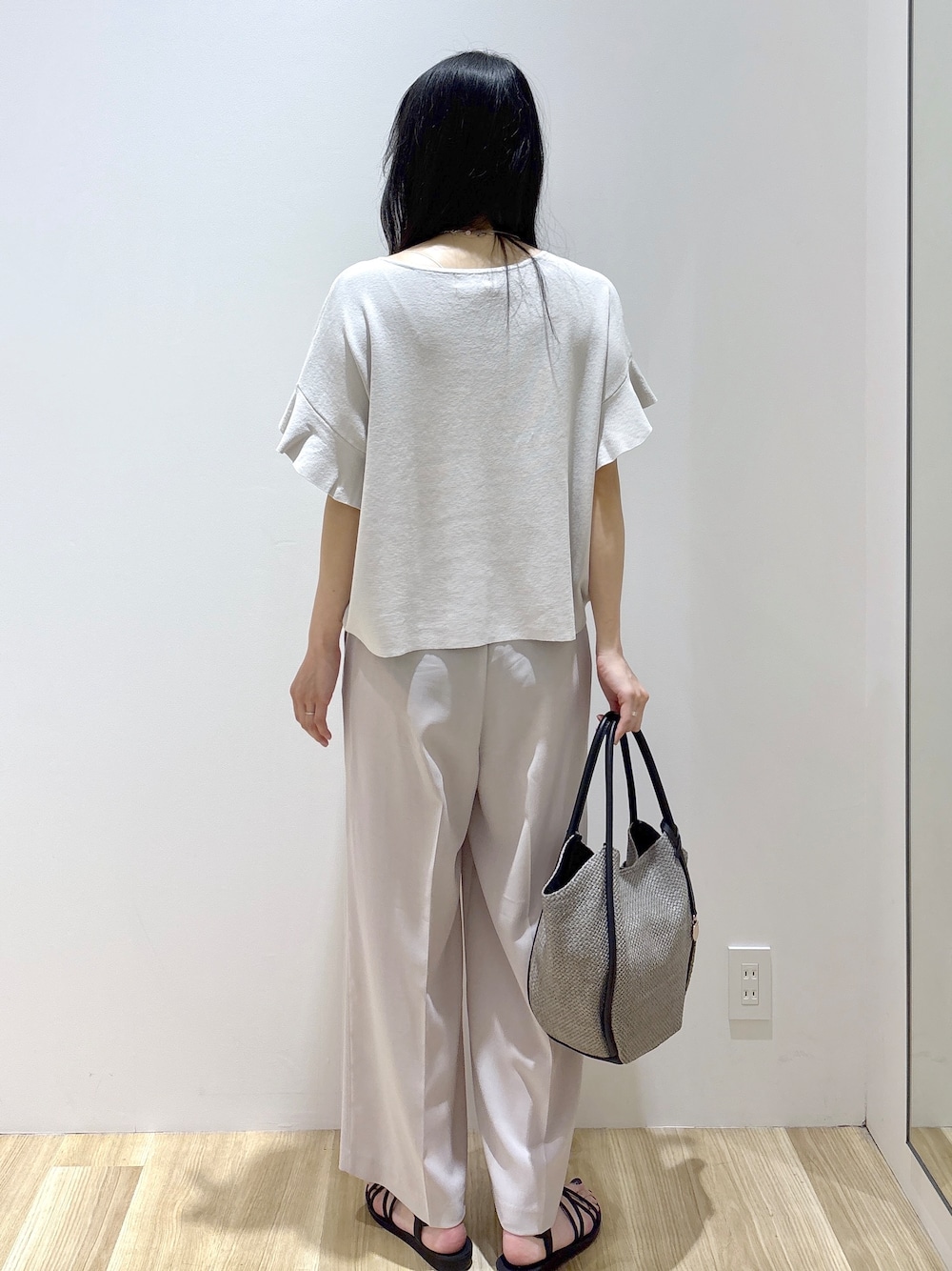 ベージュ系のその他パンツ、ブラック系のサンダル、グレー系のトートバッグを着用したレディースの春コーディネートの4枚目の写真