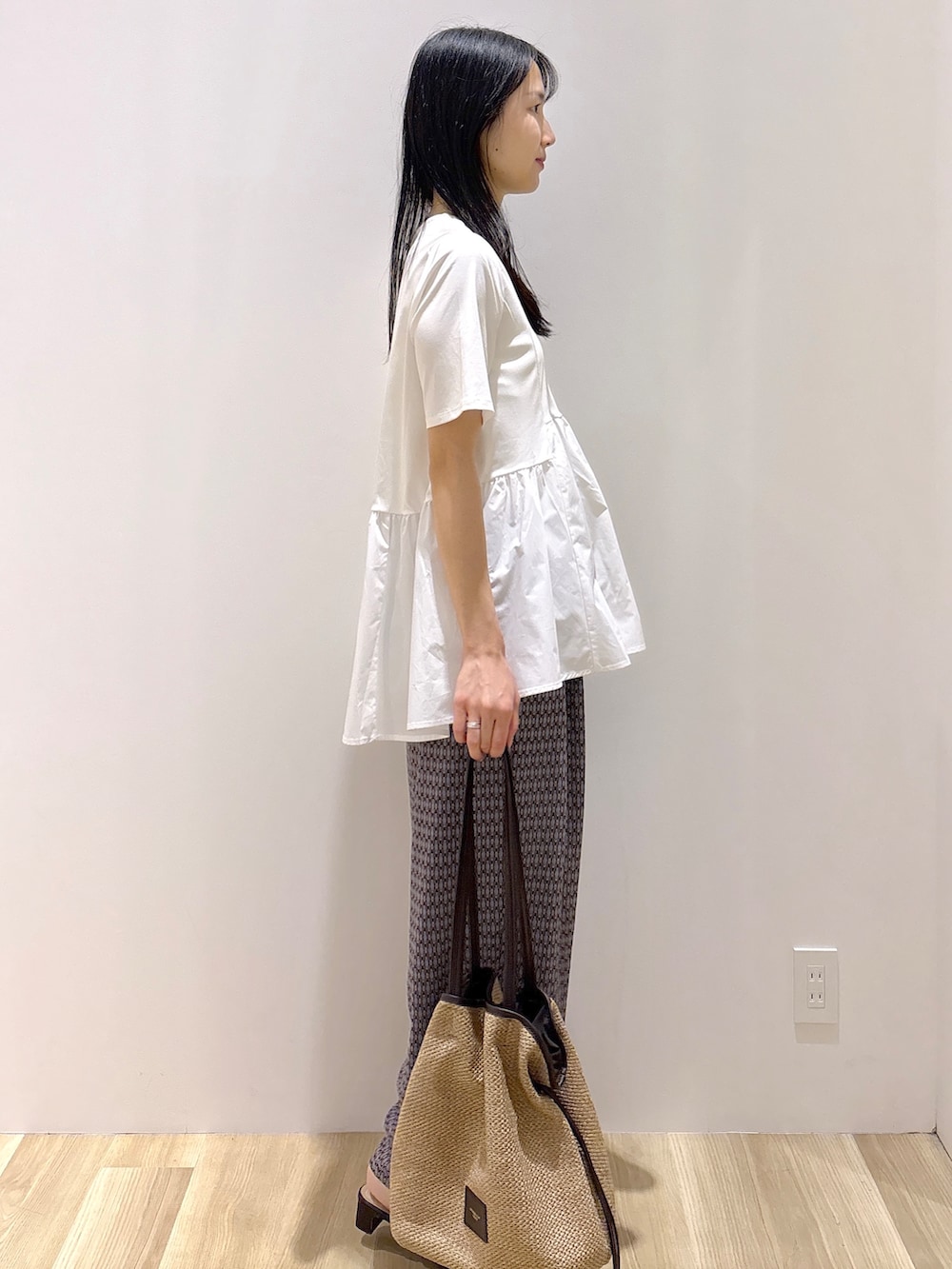 ブラウン系のサンダル、ベージュ系のトートバッグ、ホワイト系のTシャツ/カットソーを着用したレディースの春コーディネートの3枚目の写真