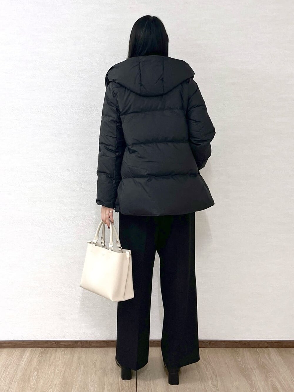 ブラック系のダウンジャケット/コート、ブルー系のニット/セーター、ブラック系のその他パンツを着用したレディースの冬コーディネートの3枚目の写真