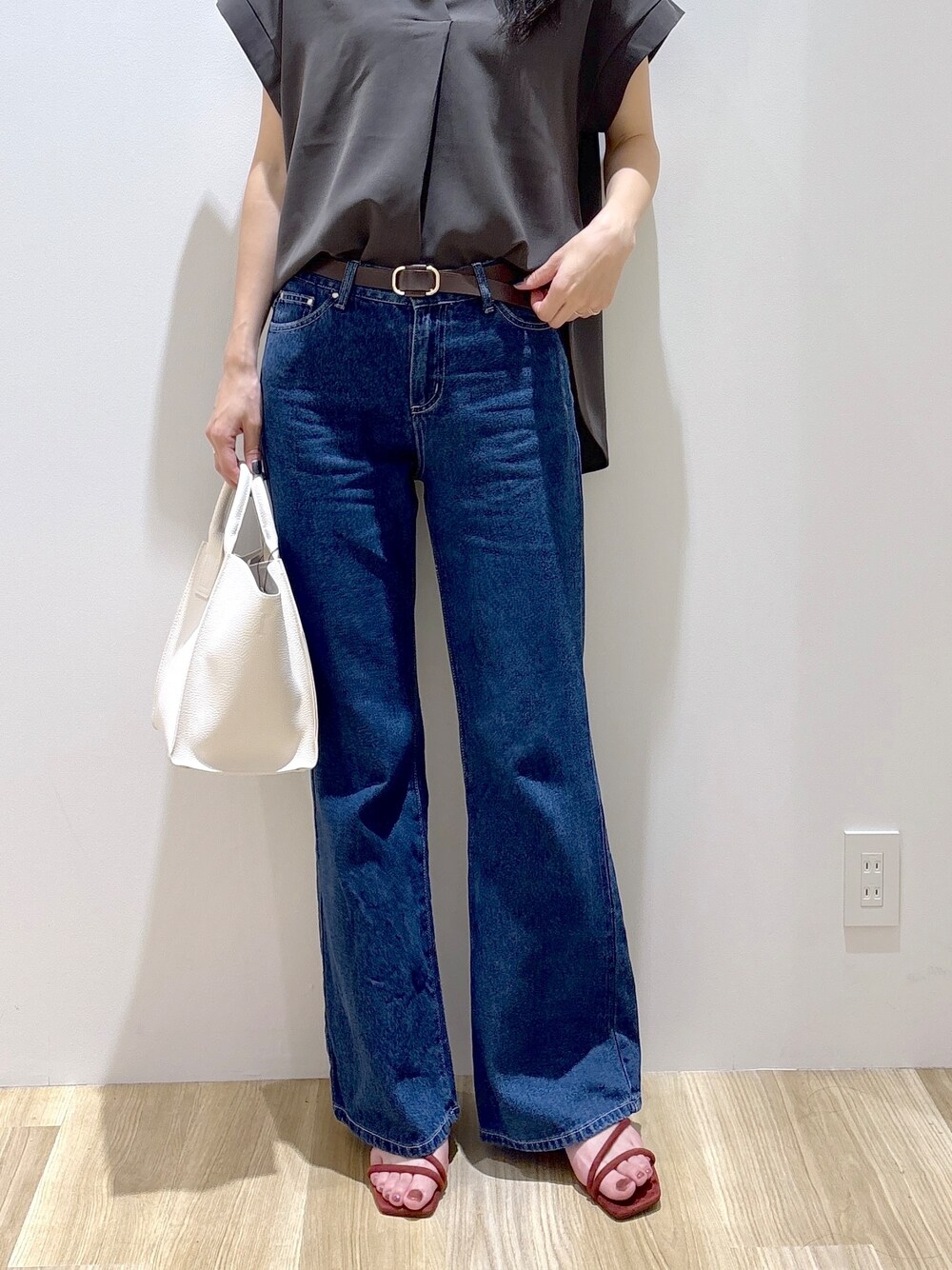 ブルー系のデニムパンツ、ホワイト系のショルダーバッグ、レッド系のサンダルを着用したレディースの夏コーディネートの7枚目の写真