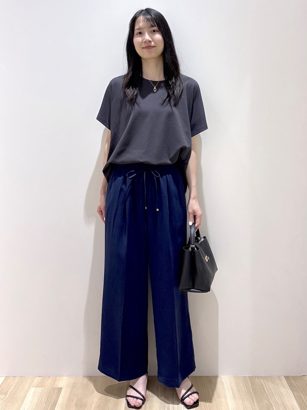 ブラック系のハンドバッグ、ベージュ系のショルダーバッグ、グレー系のTシャツ/カットソーを着用したレディースの春コーディネートの9枚目の写真