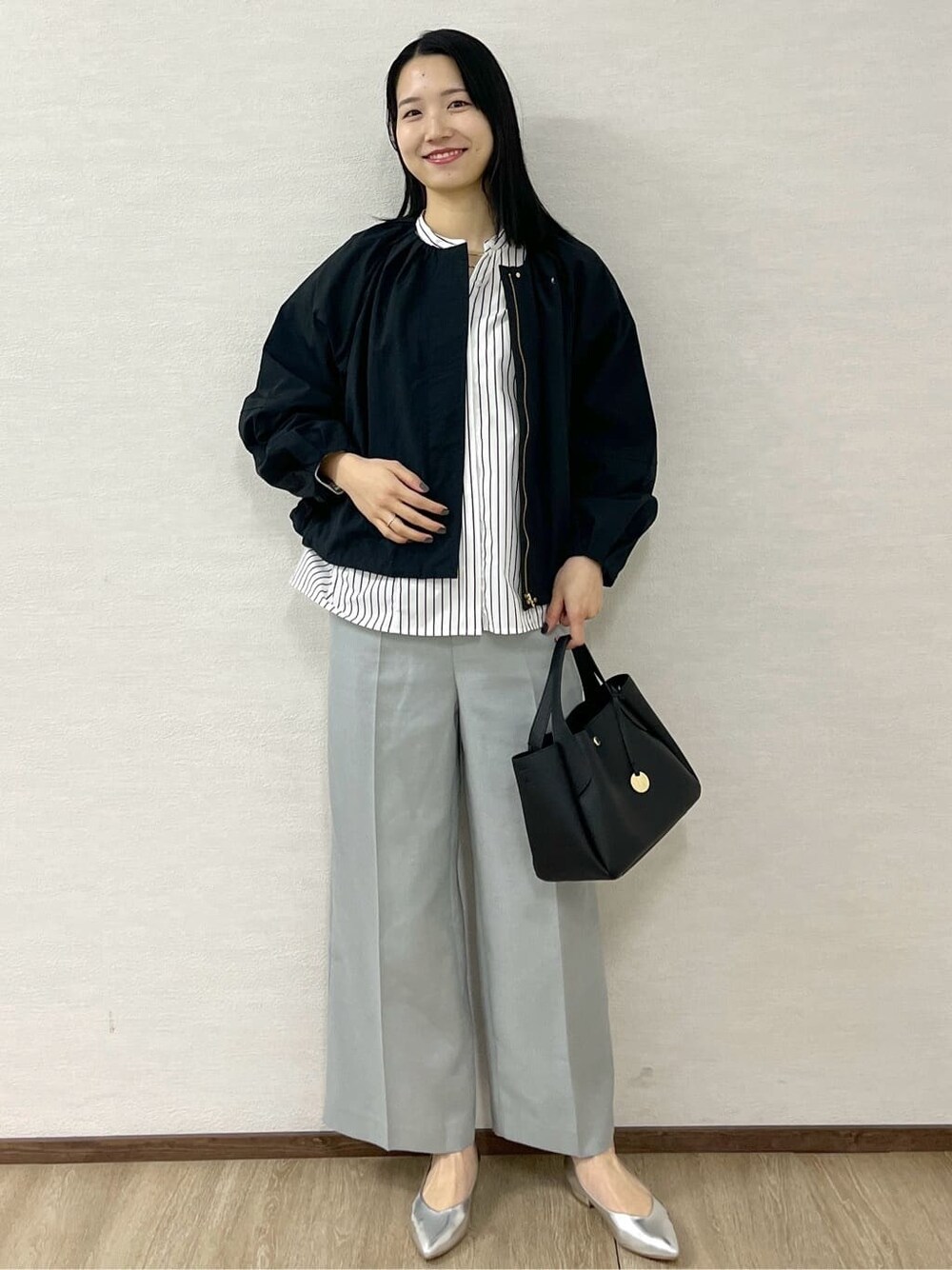 ブラック系のノーカラーコート、ホワイト系のシャツ/ブラウス、グレー系のその他パンツを着用したレディースの春コーディネートの7枚目の写真