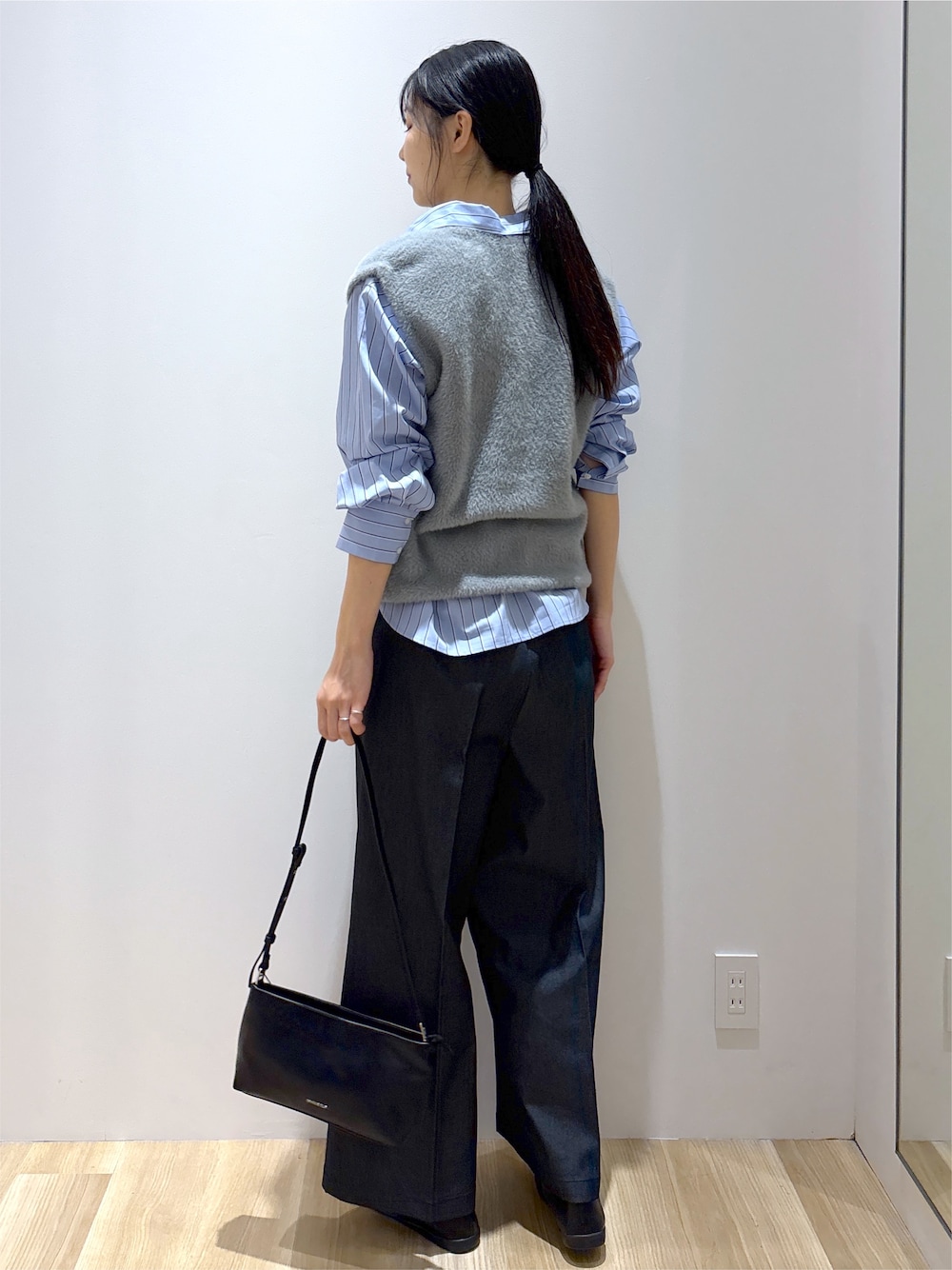グレー系のニット/セーター、ブラック系のその他パンツ、ブラック系のショルダーバッグを着用したレディースの秋コーディネートの4枚目の写真