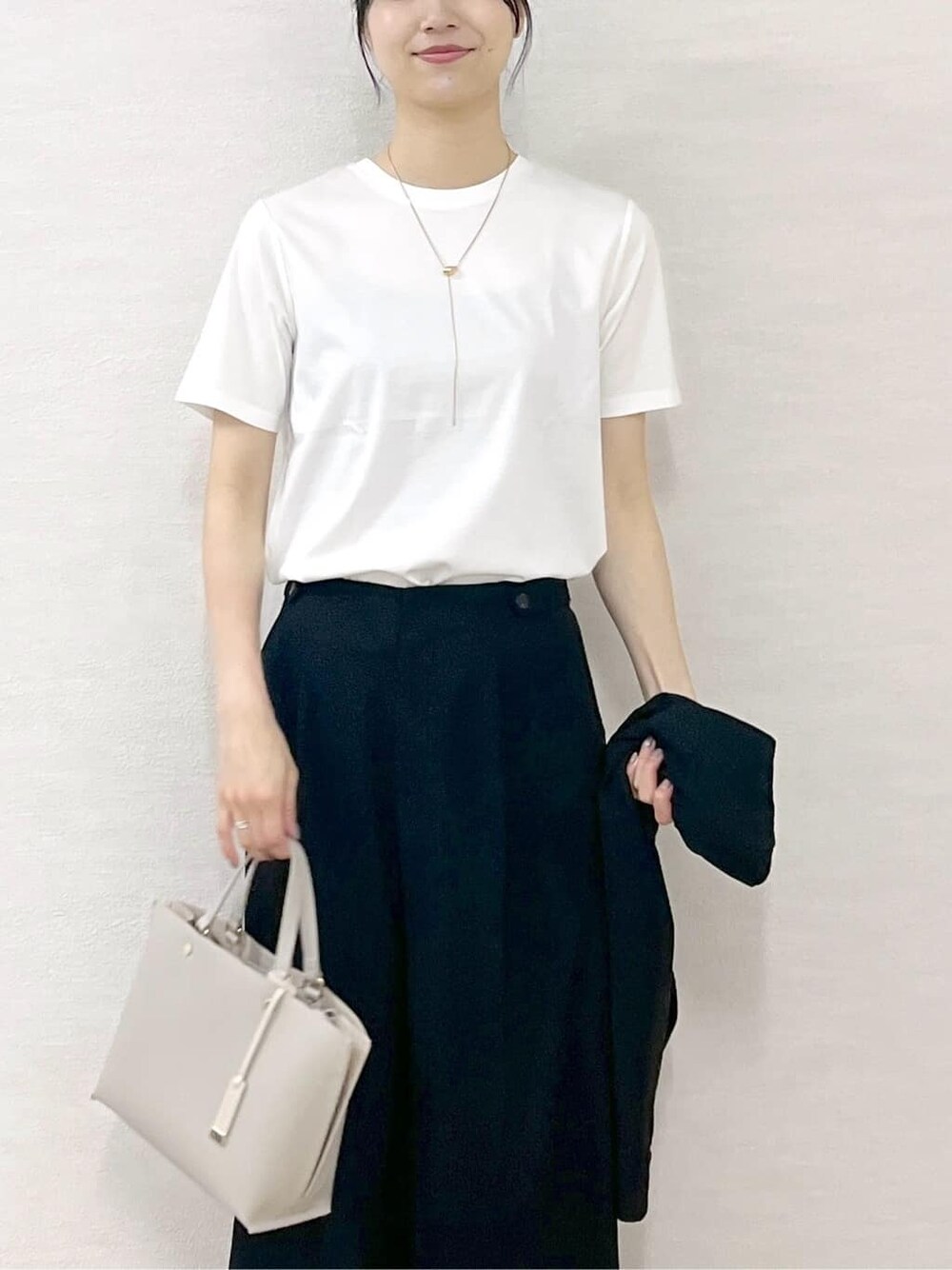 ホワイト系のTシャツ/カットソー、ブラック系のその他パンツ、ベージュ系のトートバッグを着用したレディースの夏コーディネートの6枚目の写真
