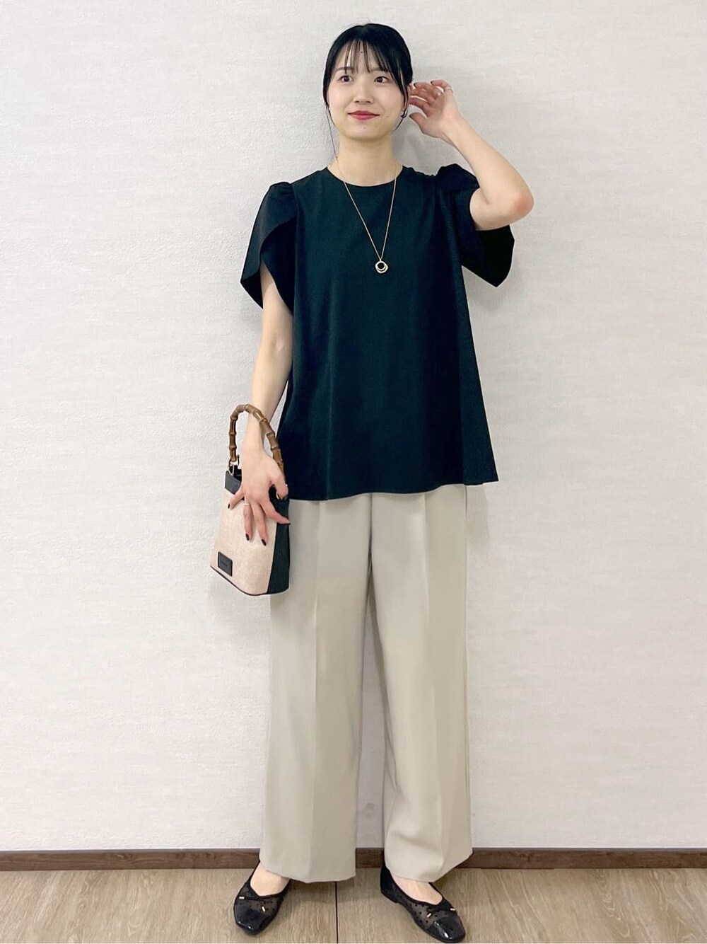 ブラック系のTシャツ/カットソー、ベージュ系のその他パンツ、ブラック系のショルダーバッグを着用したレディースの春コーディネートの9枚目の写真