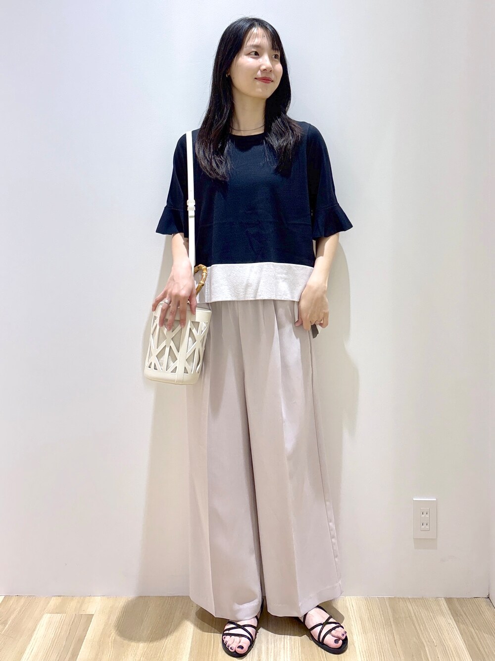 ブラック系のニット/セーター、ベージュ系のその他パンツ、ホワイト系のハンドバッグを着用したレディースの夏コーディネートの10枚目の写真