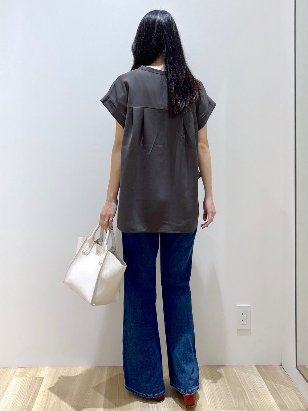 ブルー系のデニムパンツ、ホワイト系のショルダーバッグ、レッド系のサンダルを着用したレディースの夏コーディネートの4枚目の写真