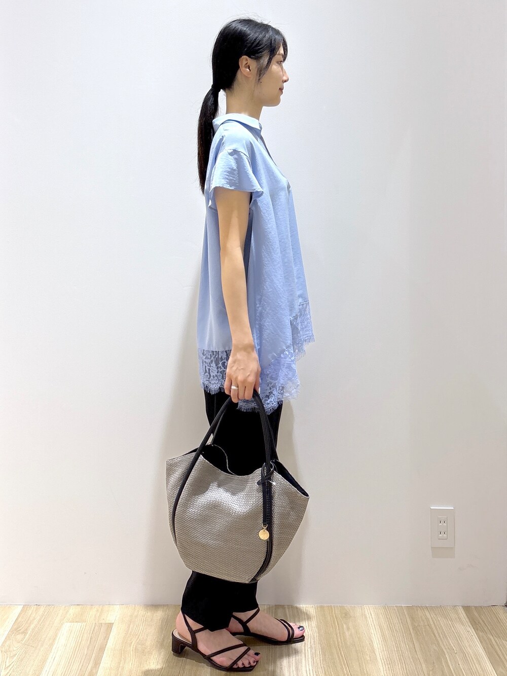 ブルー系のシャツ/ブラウス、ブラック系のその他パンツ、グレー系のトートバッグを着用したレディースの春コーディネートの4枚目の写真