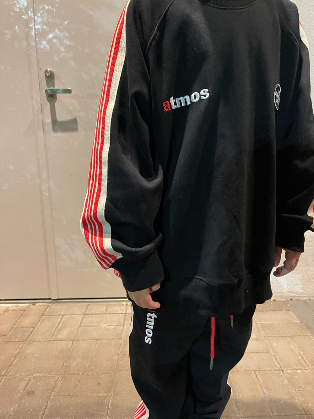 ブラック系のスウェット、ブラック系のスウェットパンツ、ブラック系のスニーカーを着用したキッズの秋コーディネートの4枚目の写真