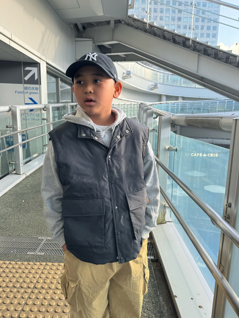 ブラック系のブルゾン、ベージュ系のカーゴパンツ、グリーン系のスニーカーを着用したキッズの春コーディネートの3枚目の写真