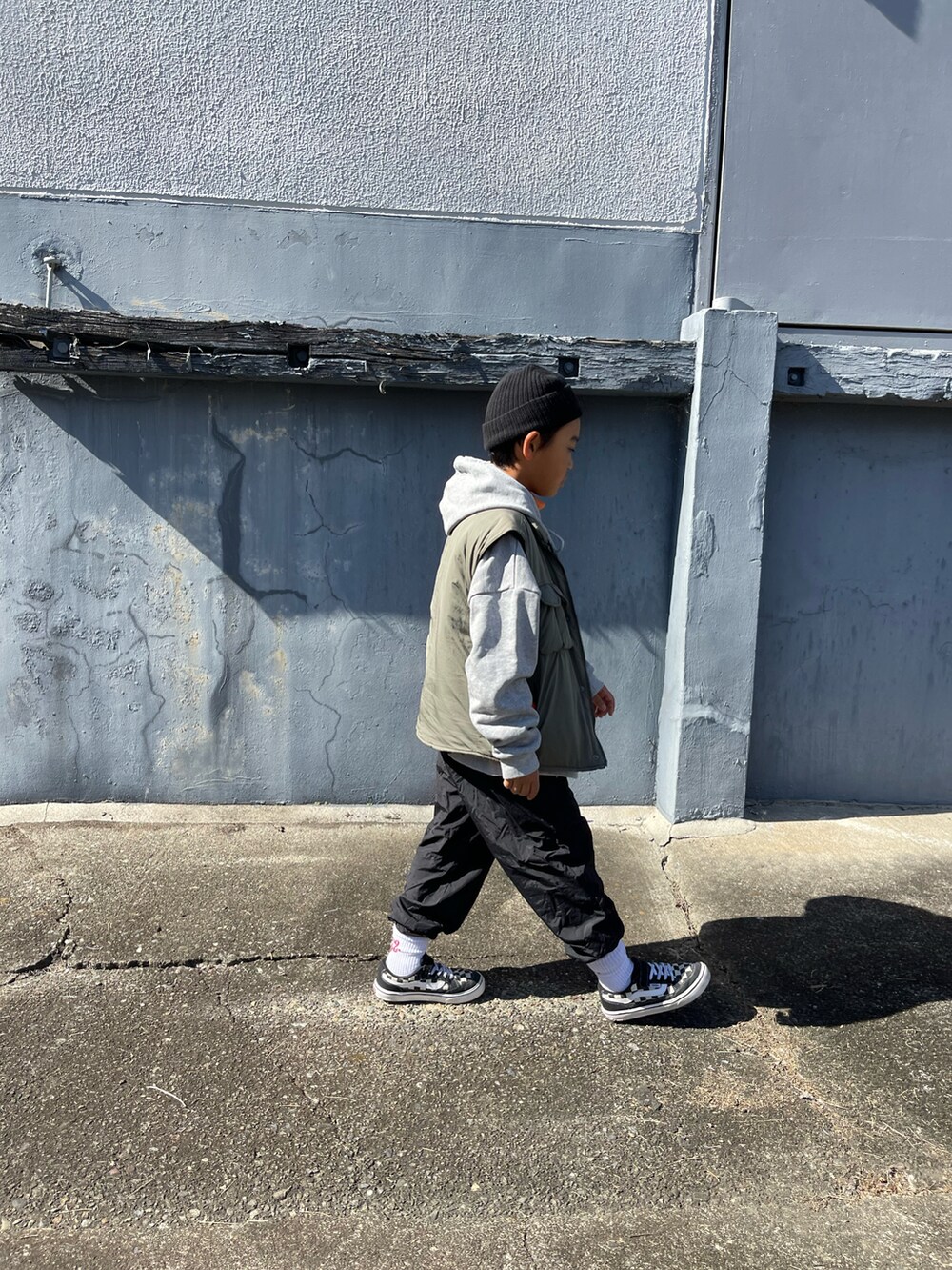 オレンジ系のトップスを着用したキッズの秋コーディネートの5枚目の写真