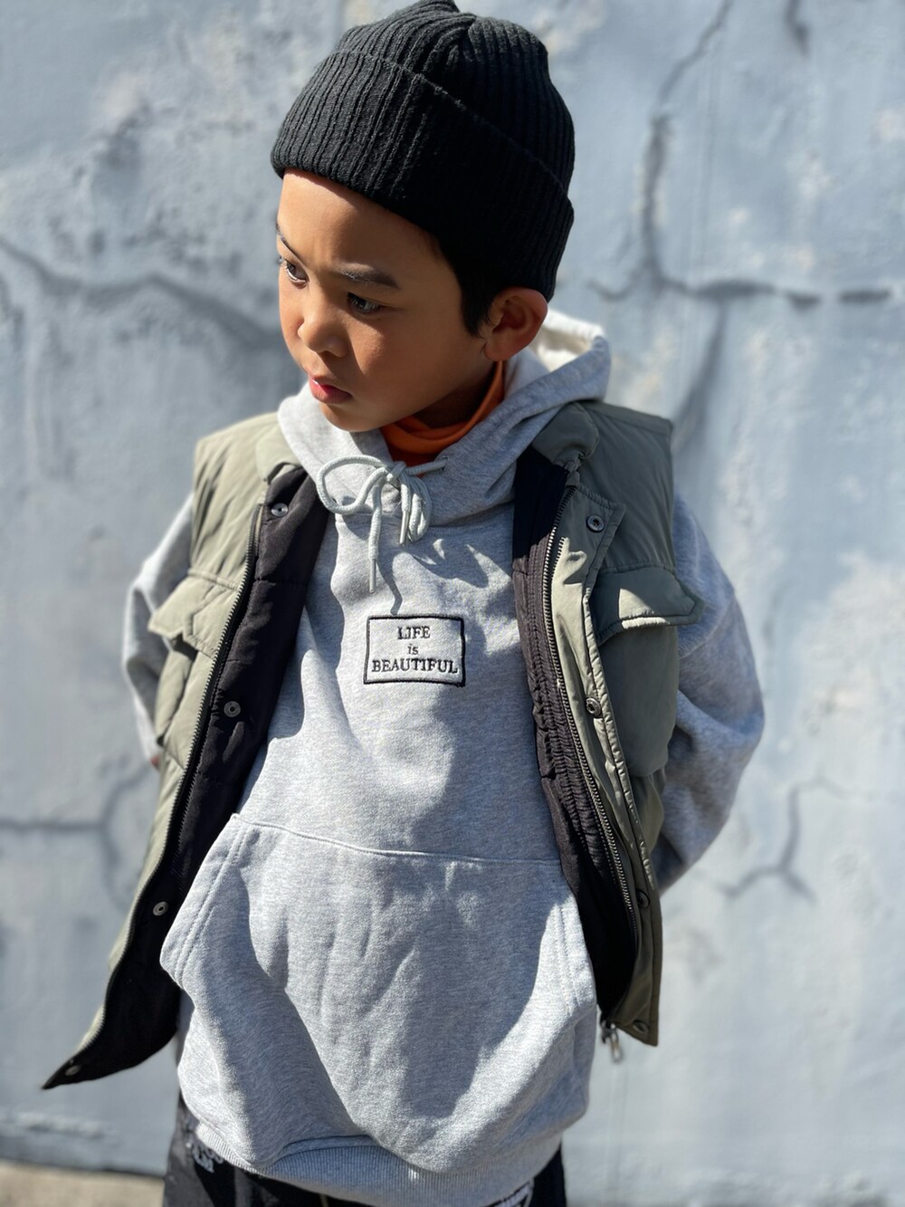 オレンジ系のトップスを着用したキッズの秋コーディネートの4枚目の写真