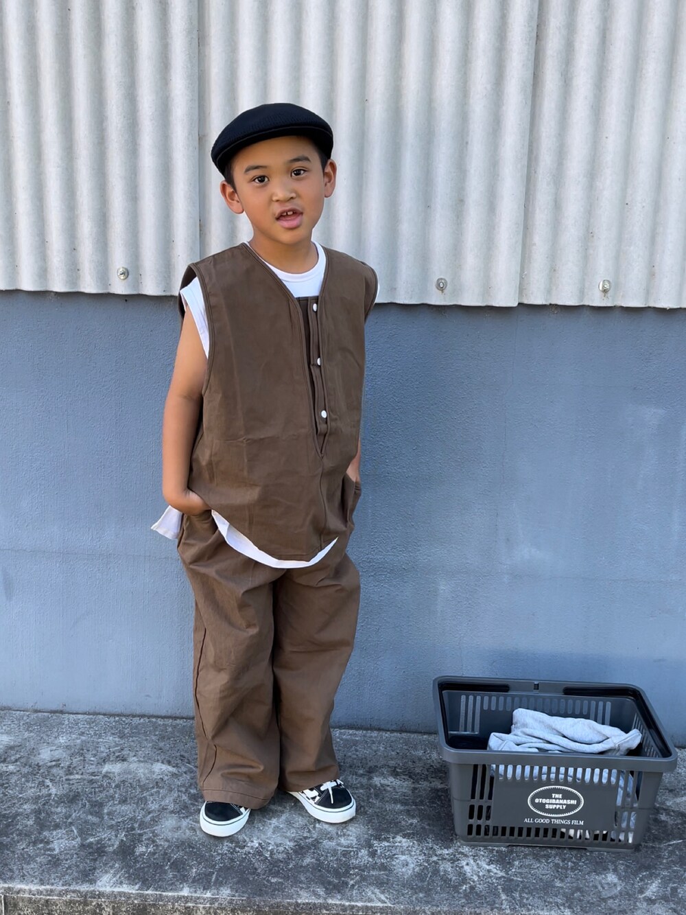 ブルー系のトップス、ブラウン系のパンツ、ブラック系のハンチング/ベレー帽を着用したキッズの夏コーディネートの2枚目の写真