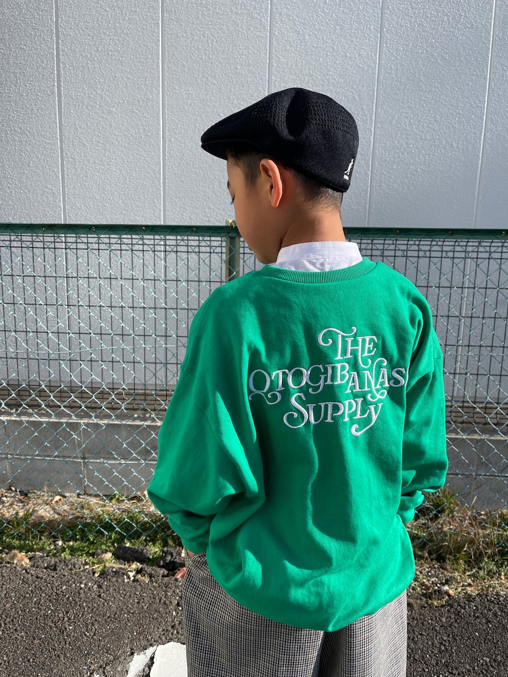 ブラック系のドレスシューズ、グレー系のスラックス、グリーン系のスウェットを着用したキッズの冬コーディネートの3枚目の写真