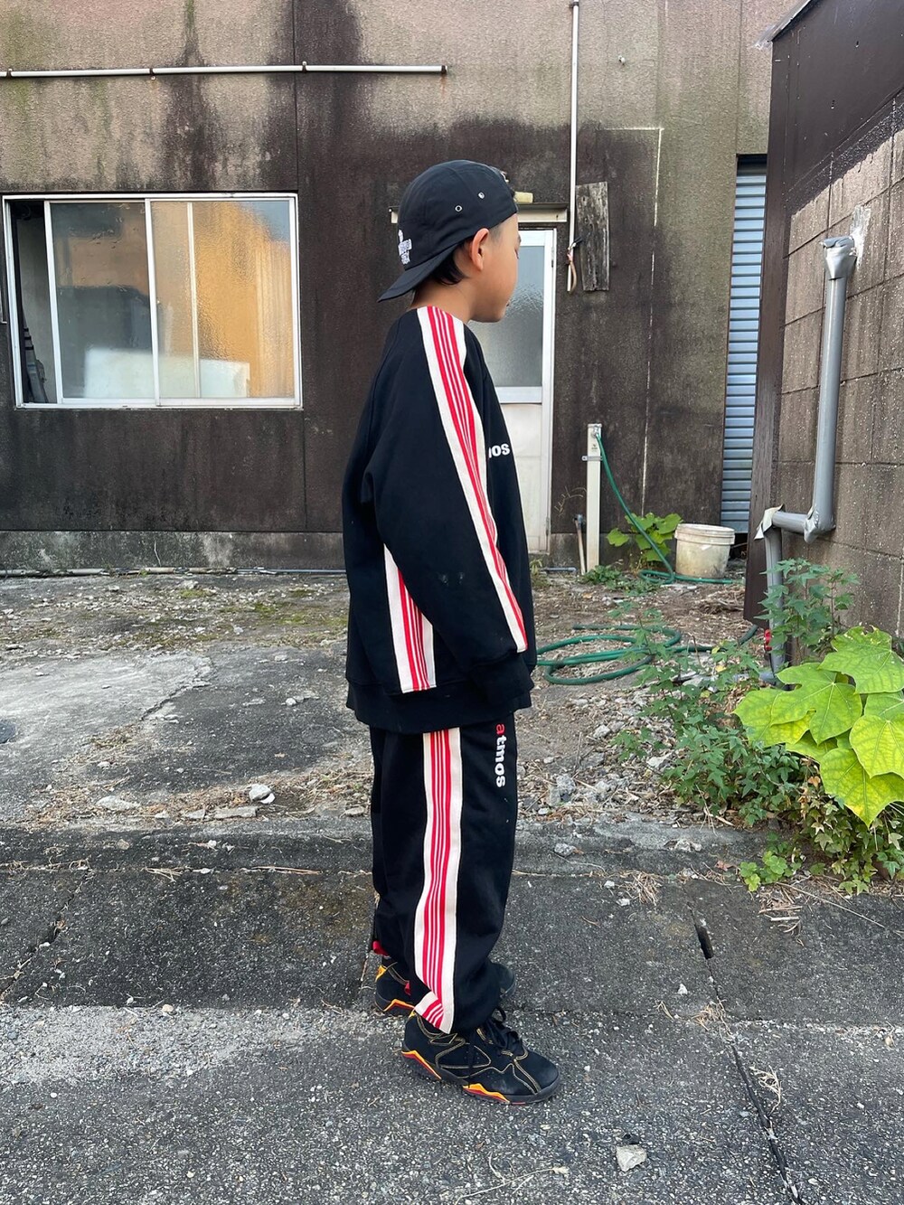 ブラック系のスウェット、ブラック系のスウェットパンツ、ブラック系のスニーカーを着用したキッズの秋コーディネートの2枚目の写真