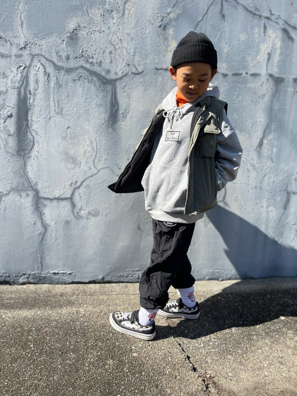 オレンジ系のトップスを着用したキッズの秋コーディネートの2枚目の写真