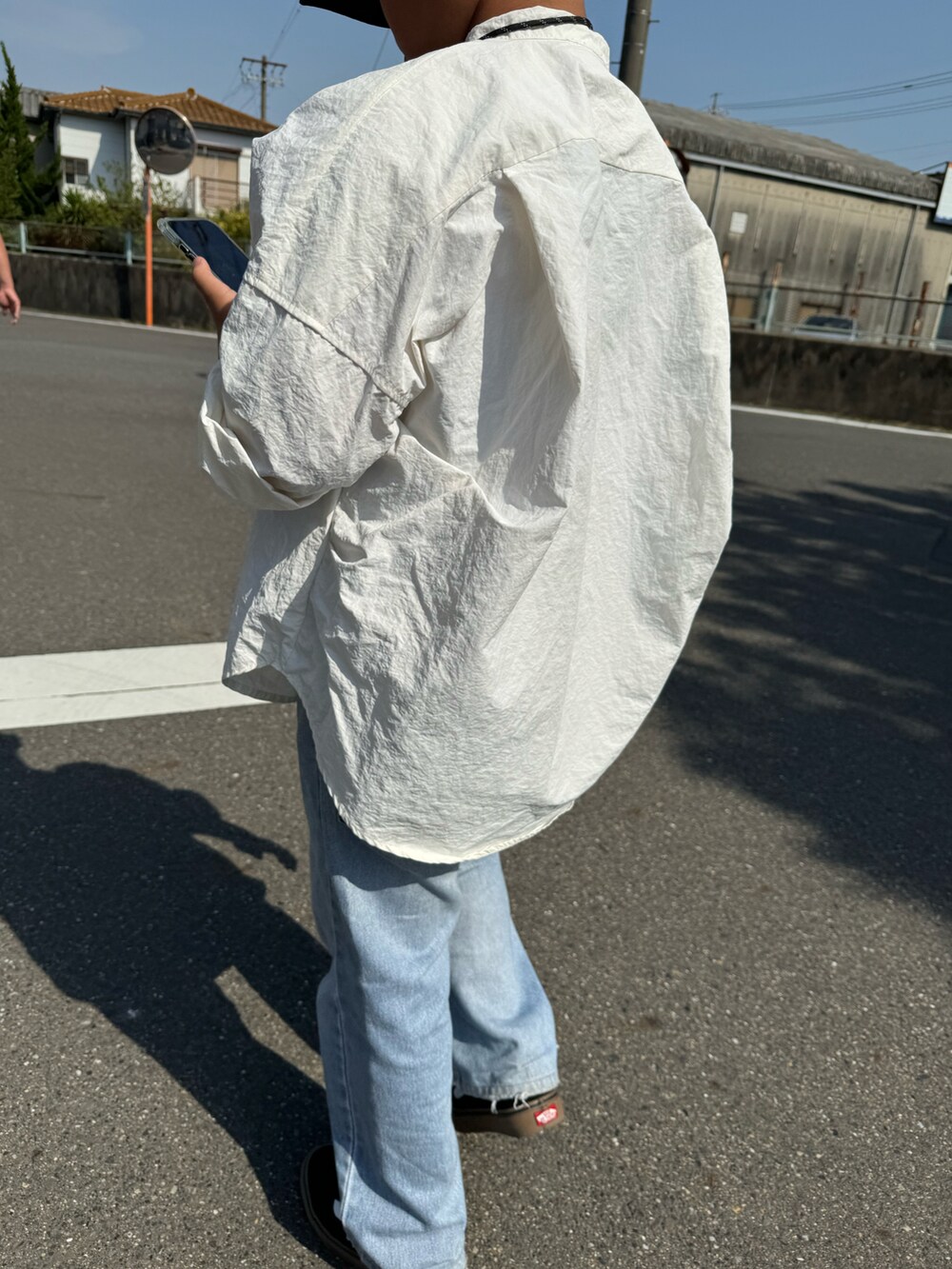 ブルー系のデニムパンツ、ブラック系のシューズ、オレンジ系のコインケースを着用したキッズの春コーディネートの2枚目の写真