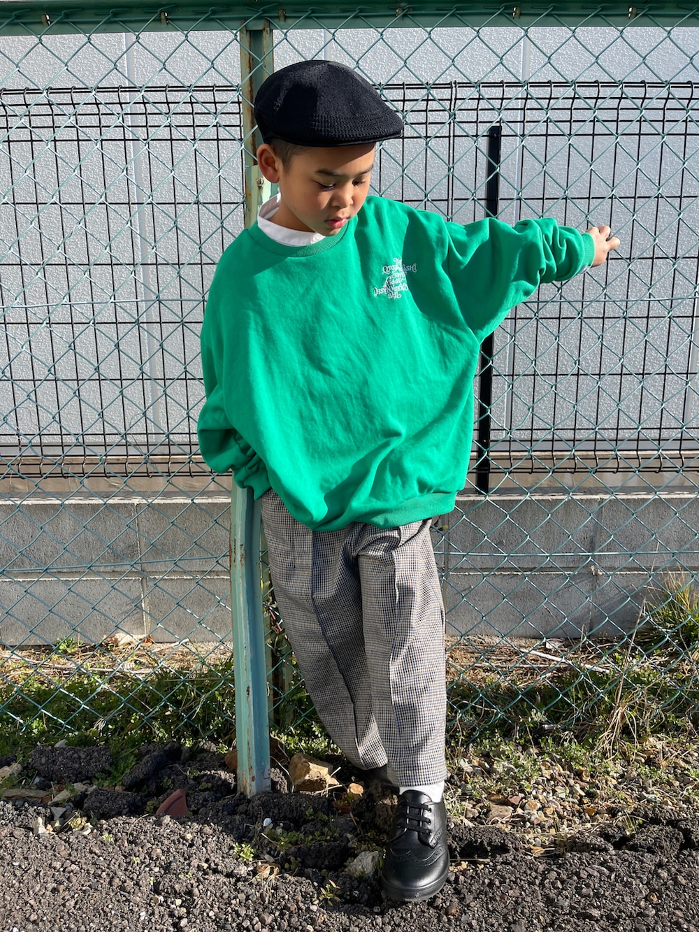 ブラック系のドレスシューズ、グレー系のスラックス、グリーン系のスウェットを着用したキッズの冬コーディネートの4枚目の写真