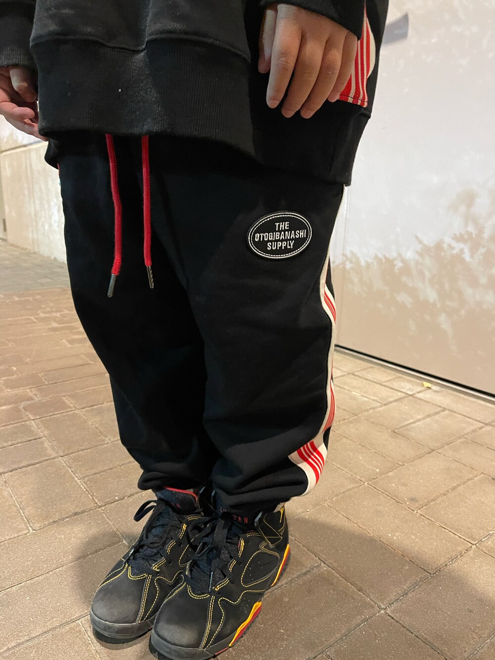 ブラック系のスウェット、ブラック系のスウェットパンツ、ブラック系のスニーカーを着用したキッズの秋コーディネートの5枚目の写真