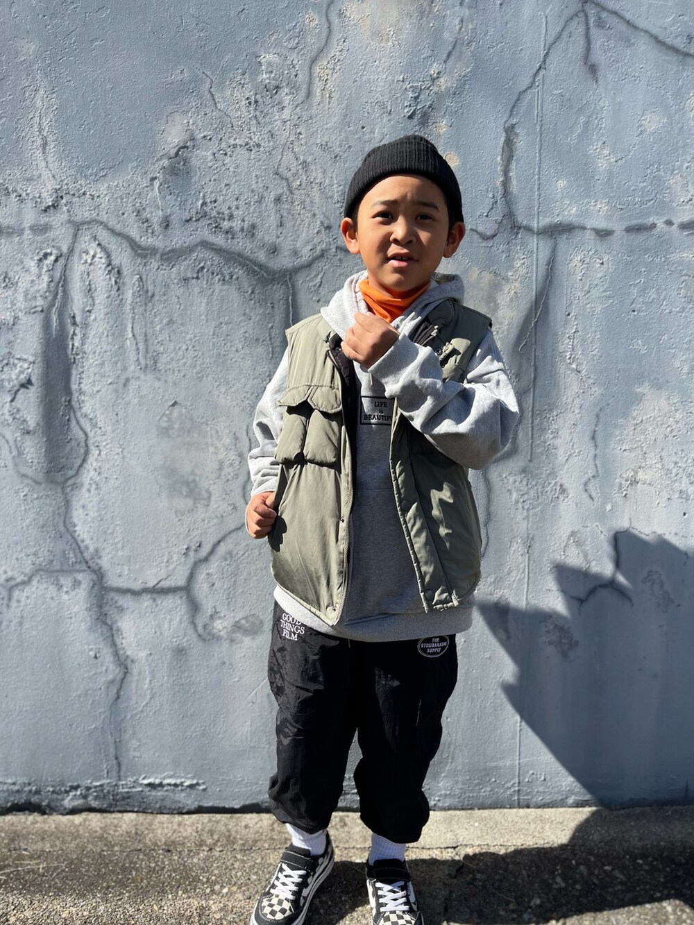 オレンジ系のトップスを着用したキッズの秋コーディネートの3枚目の写真