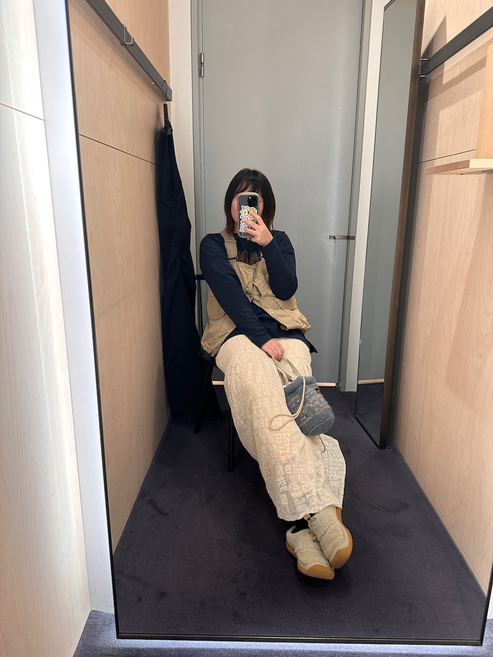 ベージュ系のスカート、ベージュ系のベスト、ブルー系のトップスを着用したレディースの冬コーディネートの2枚目の写真