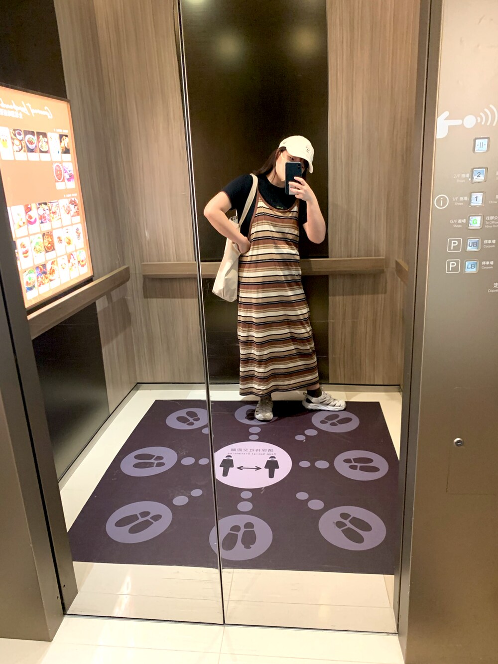 ブラウン系のワンピース、ブラック系のTシャツ/カットソー、ホワイト系のサンダルを着用したレディースの秋コーディネートの2枚目の写真