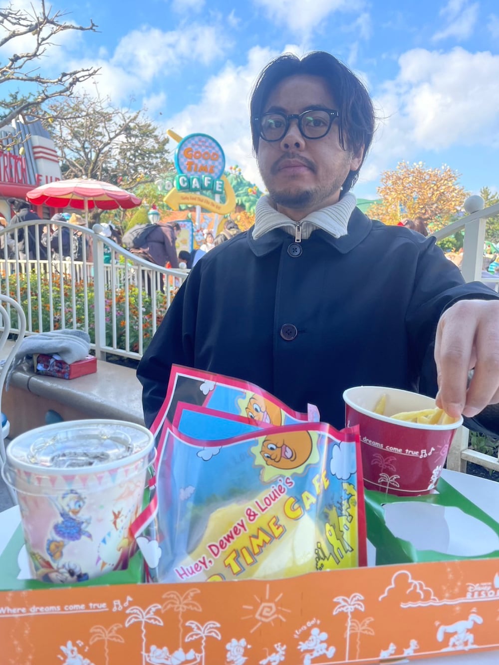 ブラック系のトレンチコート、ブラック系のスニーカー、ブラック系のチノパンツを着用したメンズの冬コーディネートの2枚目の写真